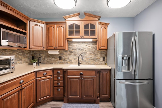 25455 145th St NW, Zimmerman, MN 55398 - kitchen featuring appliances with stainless steel finishes, a sink, light wood-type flooring, and light countertops