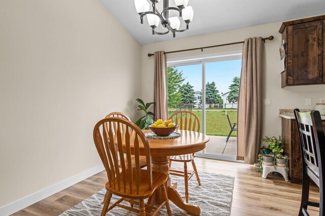 783 Park Brook Rd NW, Isanti, MN 55040 - dining room featuring a chandelier, lofted ceiling, light wood-style floors, and baseboards
