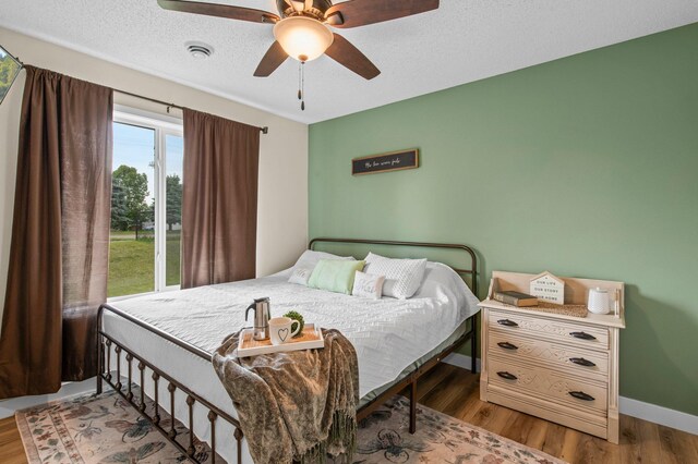 783 Park Brook Rd NW, Isanti, MN 55040 - bedroom featuring wood finished floors, baseboards, ceiling fan, and a textured ceiling