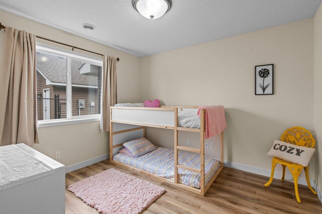 783 Park Brook Rd NW, Isanti, MN 55040 - bedroom featuring baseboards, wood finished floors, and a textured ceiling
