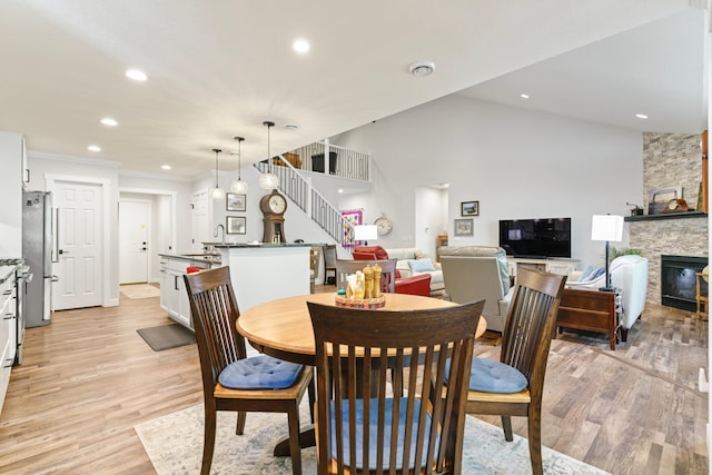 1884 Alexander Rd NE, Rochester, MN 55906 - dining space featuring stairs, light wood finished floors, recessed lighting, a stone fireplace, and crown molding