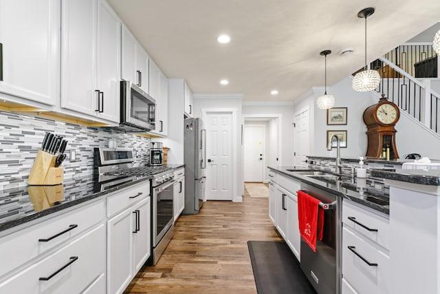 1884 Alexander Rd NE, Rochester, MN 55906 - kitchen featuring stainless steel appliances, a sink, ornamental molding, white cabinetry, and wood finished floors