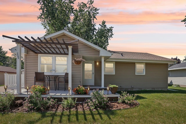 7549 Lyric Ln NE, Fridley, MN 55432 - back of house at dusk with a yard, covered porch, and a pergola