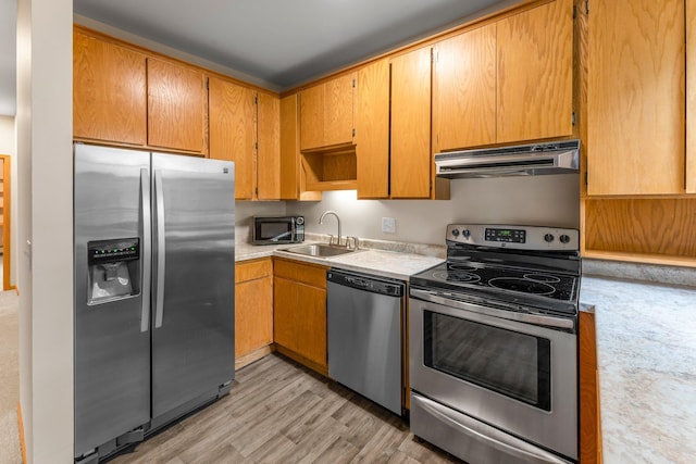 546 Laurel Ave Unit 6, Saint Paul, MN 55102 - kitchen with exhaust hood, appliances with stainless steel finishes, a sink, light countertops, and light wood-type flooring
