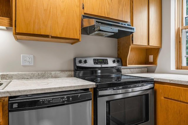 546 Laurel Ave Unit 6, Saint Paul, MN 55102 - kitchen with stainless steel appliances, under cabinet range hood, light countertops, and brown cabinets