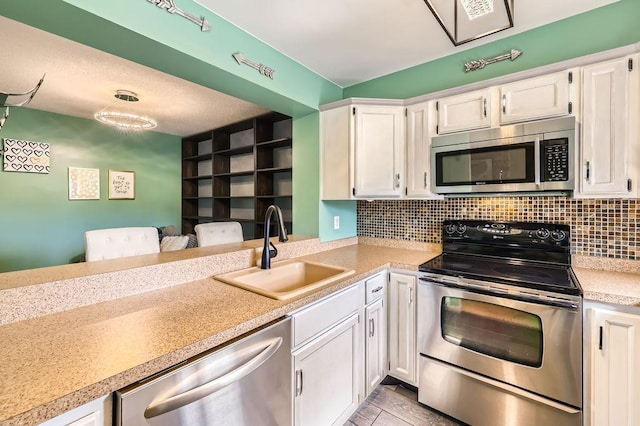 2060 Pathways Dr Unit 13, Saint Paul, MN 55119 - kitchen featuring appliances with stainless steel finishes, a sink, white cabinets, light countertops, and decorative backsplash