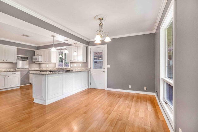 5313 Birchcrest Dr, Edina, MN 55436 - kitchen with white microwave, stainless steel oven, crown molding, light wood finished floors, and white cabinets