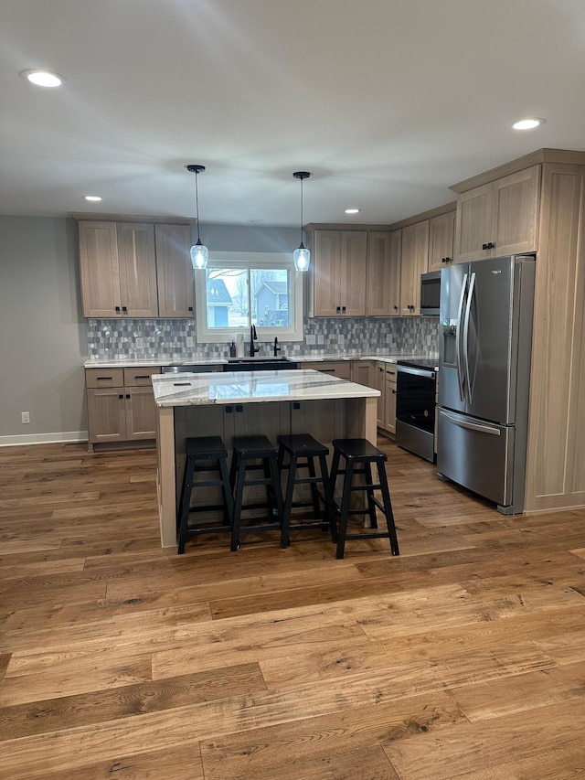 1911 Johnson St, Albert Lea, MN 56007 - kitchen featuring appliances with stainless steel finishes, a sink, a center island, wood finished floors, and tasteful backsplash