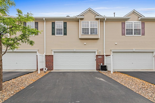 3537 Cherry Ln Unit C, Woodbury, MN 55129 - view of property featuring driveway, brick siding, and a garage