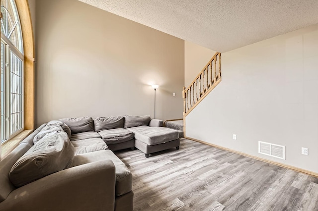 1127 Ridgestone Pl, Buffalo, MN 55313 - living area featuring wood finished floors, stairs, healthy amount of natural light, and a textured ceiling