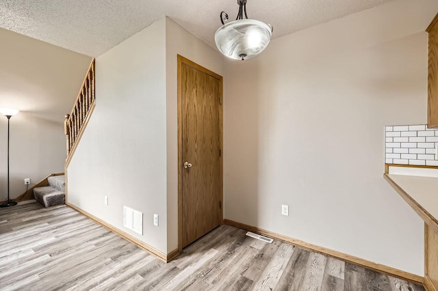 1127 Ridgestone Pl, Buffalo, MN 55313 - foyer entrance featuring light wood finished floors, stairway, and a textured ceiling