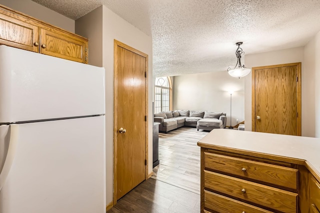 1127 Ridgestone Pl, Buffalo, MN 55313 - kitchen featuring freestanding refrigerator, a textured ceiling, wood finished floors, brown cabinetry, and light countertops