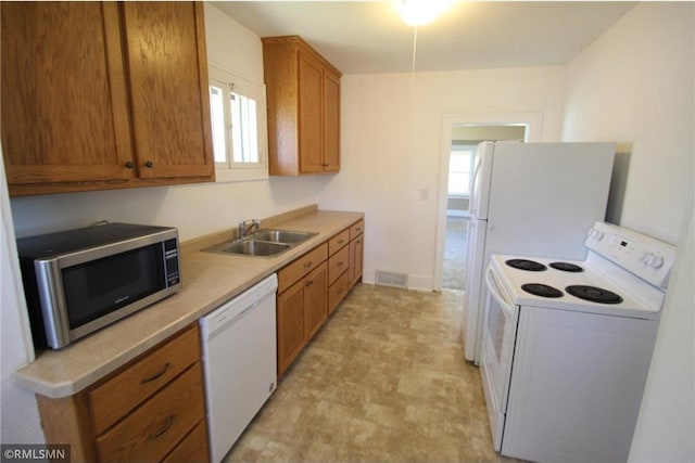 132 4th Ave N, Waite Park, MN 56387 - kitchen with white appliances, a sink, brown cabinetry, light floors, and light countertops
