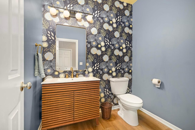 11275 Preswick Blvd, Eden Prairie, MN 55344 - half bathroom featuring wallpapered walls, wood finished floors, toilet, vanity, and baseboards