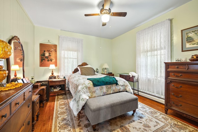 35746 585th Ave, Lafayette, MN 56054 - bedroom with baseboard heating, wood finished floors, and a ceiling fan
