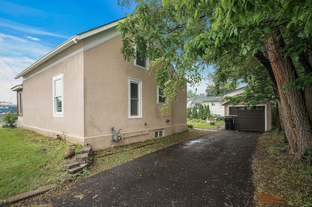 414 Western Ln, Anoka, MN 55303 - view of home's exterior with driveway, stucco siding, and an outbuilding