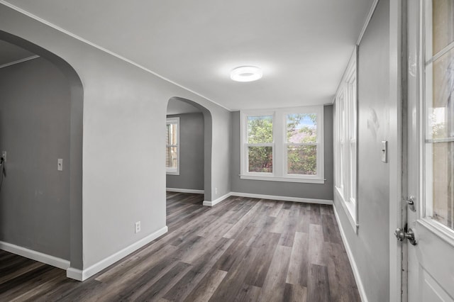 414 Western Ln, Anoka, MN 55303 - unfurnished room featuring dark wood-style floors, baseboards, arched walkways, and crown molding