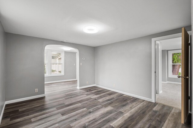 414 Western Ln, Anoka, MN 55303 - unfurnished room featuring arched walkways, wood finished floors, and baseboards