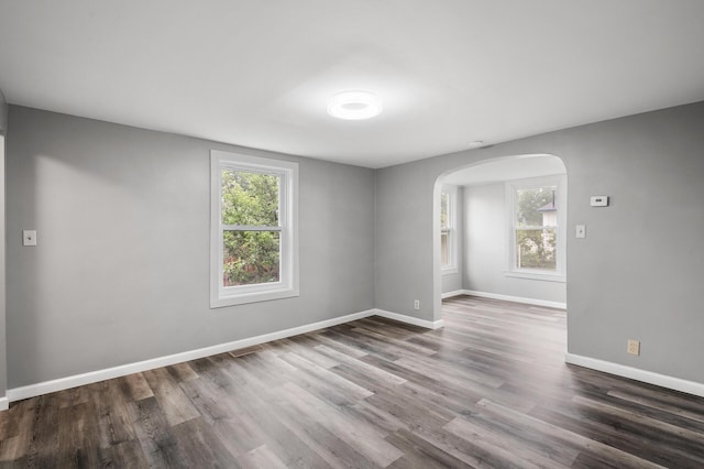 414 Western Ln, Anoka, MN 55303 - unfurnished room featuring arched walkways, wood finished floors, and baseboards