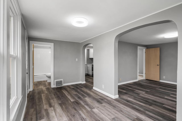414 Western Ln, Anoka, MN 55303 - unfurnished room featuring arched walkways, dark wood-type flooring, baseboards, and ornamental molding