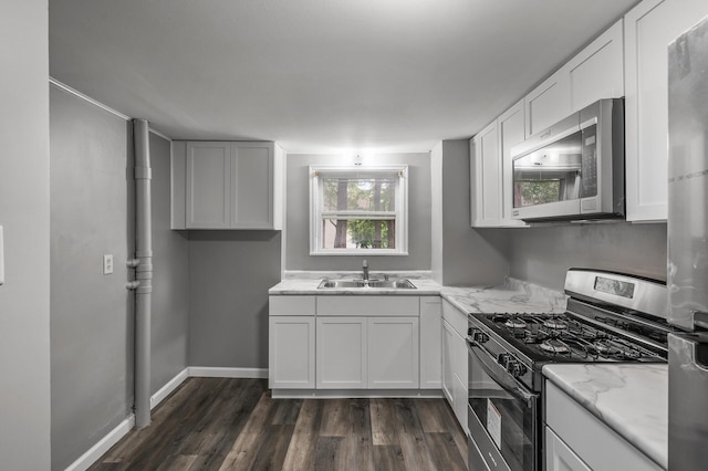 414 Western Ln, Anoka, MN 55303 - kitchen with appliances with stainless steel finishes, a sink, dark wood-type flooring, white cabinetry, and light stone counters