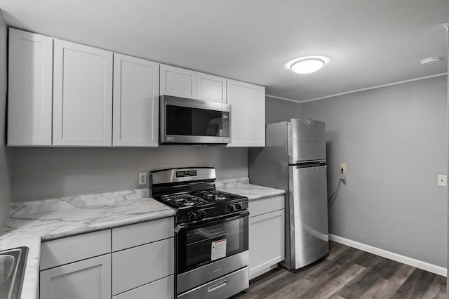 414 Western Ln, Anoka, MN 55303 - kitchen with appliances with stainless steel finishes, white cabinetry, dark wood-type flooring, light stone countertops, and baseboards