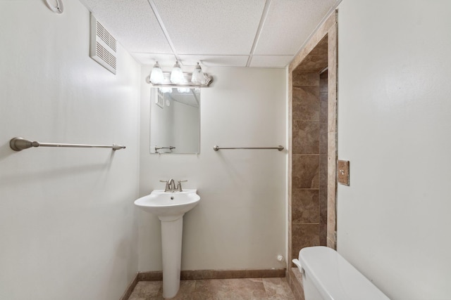 225 7th Ave NE, Osseo, MN 55369 - bathroom featuring toilet, a drop ceiling, a sink, and baseboards