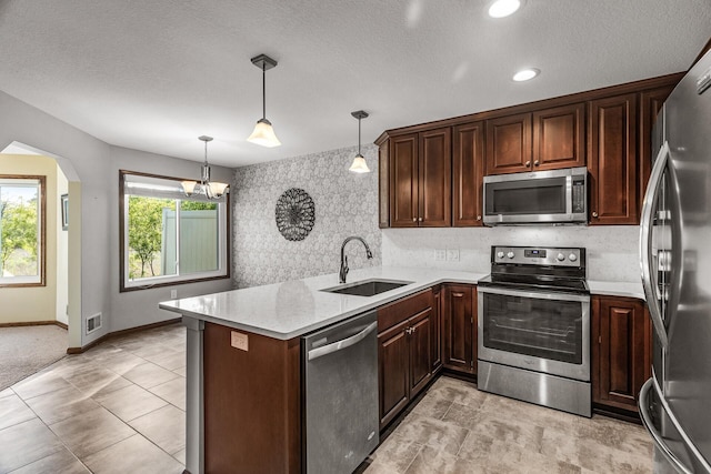 7582 Ojibway Park Bay, Woodbury, MN 55125 - kitchen with stainless steel appliances, a peninsula, hanging light fixtures, dark brown cabinetry, and a chandelier