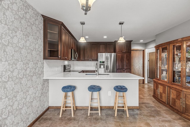 7582 Ojibway Park Bay, Woodbury, MN 55125 - kitchen with stainless steel appliances, wallpapered walls, glass insert cabinets, a peninsula, and light countertops