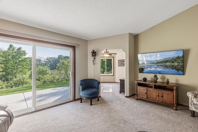 7582 Ojibway Park Bay, Woodbury, MN 55125 - sitting room with light carpet, a textured ceiling, ceiling fan, and arched walkways