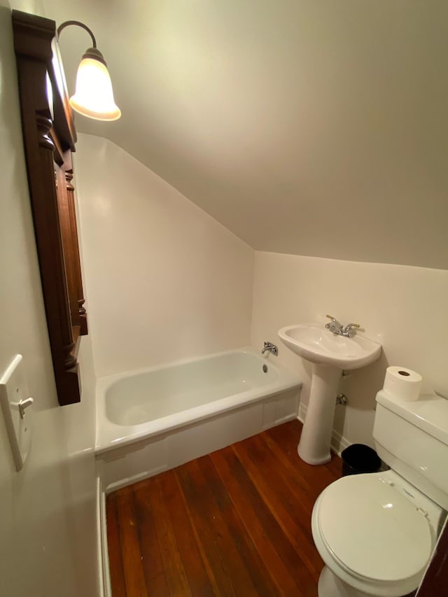 1315 Clark St W, Albert Lea, MN 56007 - full bath featuring a tub to relax in, vaulted ceiling, toilet, and wood finished floors