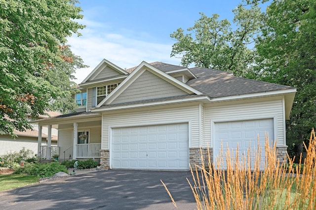 10426 Hidden Oaks Ln N, Champlin, MN 55316 - craftsman house featuring driveway, a garage, a porch, and stone siding