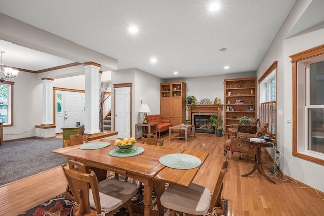 10426 Hidden Oaks Ln N, Champlin, MN 55316 - dining area with light wood-style floors, a glass covered fireplace, recessed lighting, ornate columns, and stairway