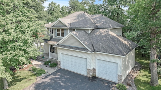 10426 Hidden Oaks Ln N, Champlin, MN 55316 - view of front of house featuring driveway, a garage, stone siding, and a shingled roof