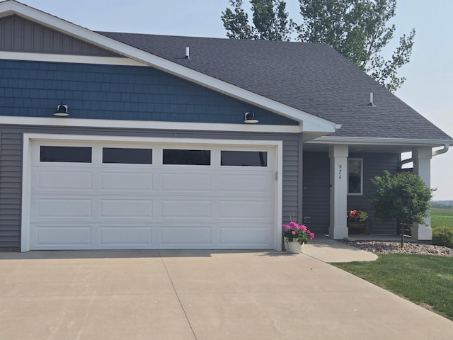 924 3rd Ave SE, Hayfield, MN 55940 - view of front of home featuring concrete driveway, roof with shingles, a garage, and covered porch