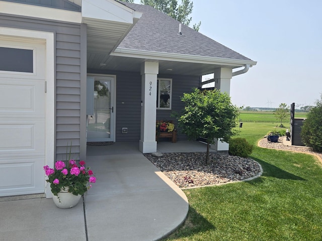 924 3rd Ave SE, Hayfield, MN 55940 - property entrance with roof with shingles, covered porch, a yard, and a garage