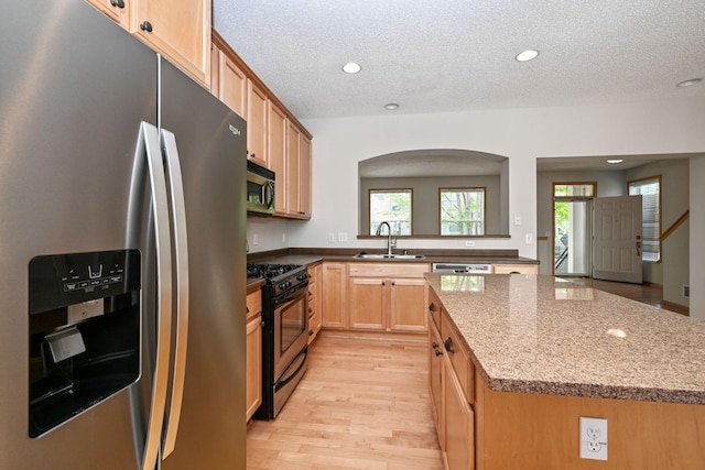 8280 Labont Way, Eden Prairie, MN 55344 - kitchen with appliances with stainless steel finishes, a sink, arched walkways, light wood-style floors, and a textured ceiling