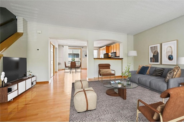 8280 Labont Way, Eden Prairie, MN 55344 - living area featuring light wood-style flooring, arched walkways, baseboards, and a textured ceiling