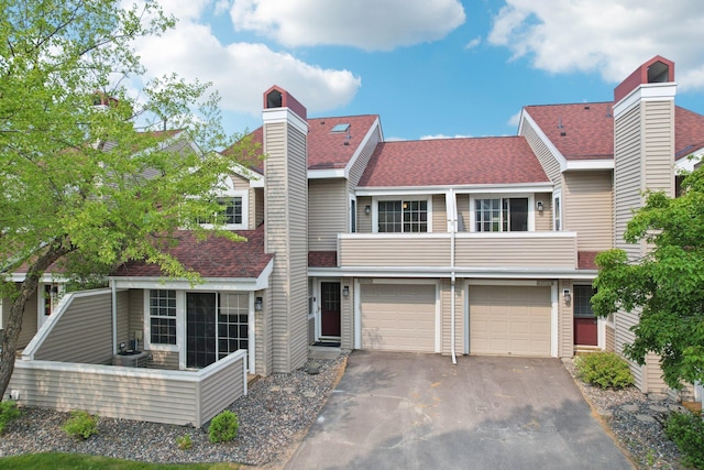 2040 Shenandoah Ct Unit B, Plymouth, MN 55447 - townhome / multi-family property featuring a balcony, a chimney, driveway, a shingled roof, and a garage
