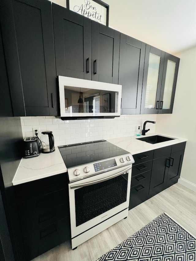 2120 Walden Blvd NW, Oak Grove, MN 55011 - kitchen with electric stove, white microwave, and dark cabinets