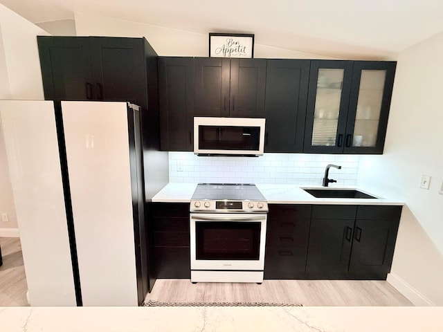 2120 Walden Blvd NW, Oak Grove, MN 55011 - kitchen featuring white microwave, stainless steel range with electric cooktop, freestanding refrigerator, vaulted ceiling, and dark cabinets