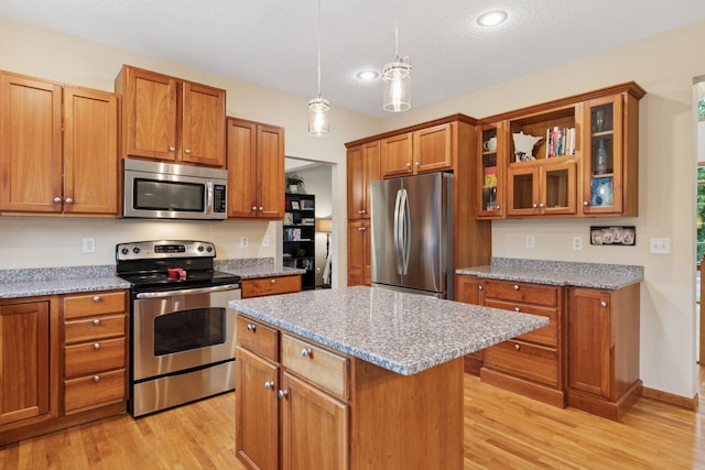2097 138th St W, Rosemount, MN 55068 - kitchen featuring stainless steel appliances, brown cabinets, light wood-type flooring, a center island, and recessed lighting