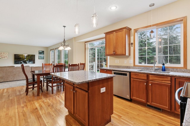 2097 138th St W, Rosemount, MN 55068 - kitchen with stainless steel dishwasher, brown cabinets, a kitchen island, light wood-style flooring, and light stone counters