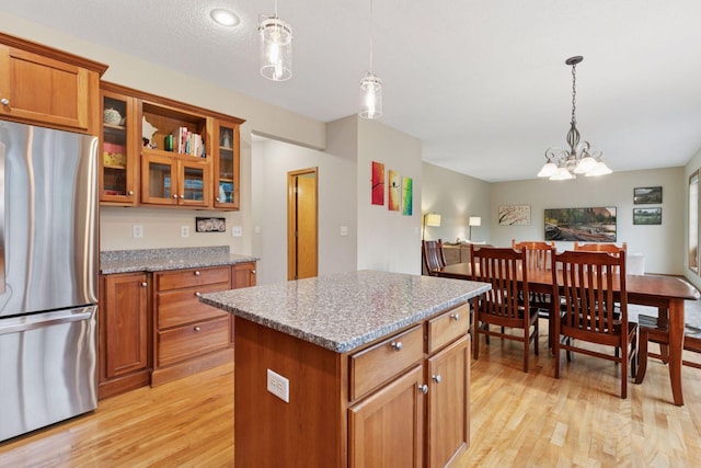 2097 138th St W, Rosemount, MN 55068 - kitchen with freestanding refrigerator, brown cabinets, light wood finished floors, and a center island