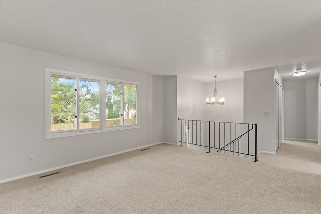 6716 83rd Ave N, Brooklyn Park, MN 55445 - empty room featuring carpet floors, a chandelier, and a textured ceiling