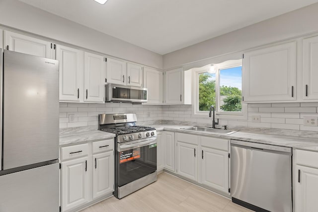 6716 83rd Ave N, Brooklyn Park, MN 55445 - kitchen with stainless steel appliances, white cabinetry, and tasteful backsplash
