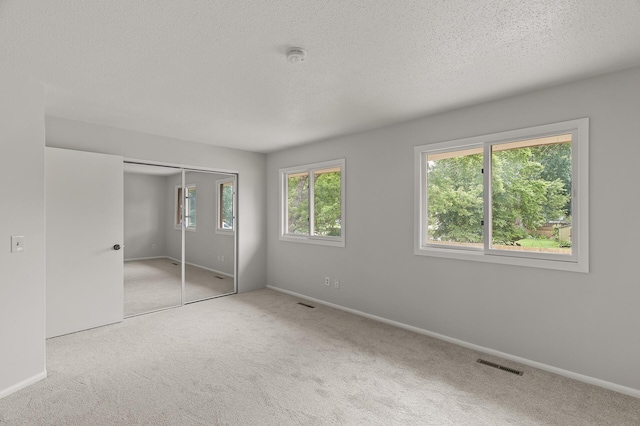 6716 83rd Ave N, Brooklyn Park, MN 55445 - unfurnished bedroom with carpet, a textured ceiling, and a closet