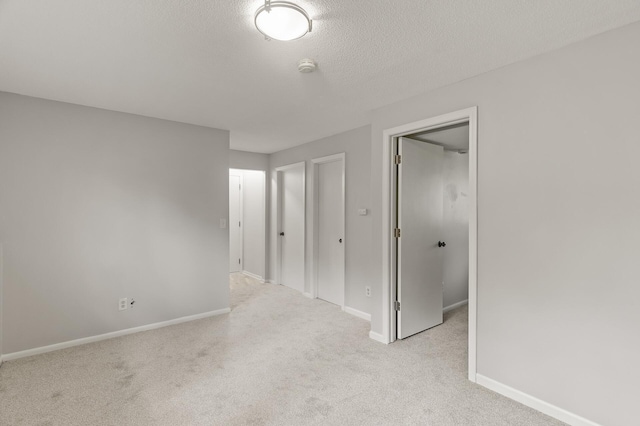 6716 83rd Ave N, Brooklyn Park, MN 55445 - unfurnished bedroom with light carpet, a walk in closet, and a textured ceiling