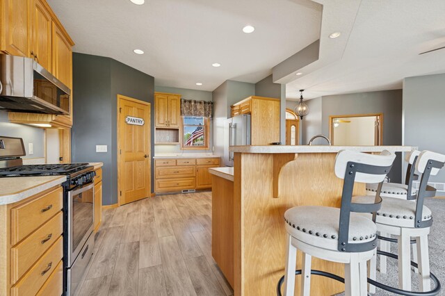 531 Depree Way, Glenwood, MN 56334 - kitchen with stainless steel appliances, a breakfast bar area, light countertops, light wood-type flooring, and a peninsula