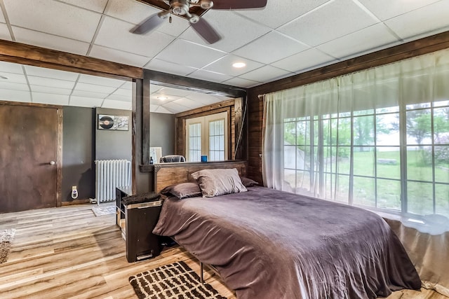 1782 225th St N, Hawley, MN 56549 - bedroom with radiator heating unit, a drop ceiling, wood finished floors, french doors, and a ceiling fan